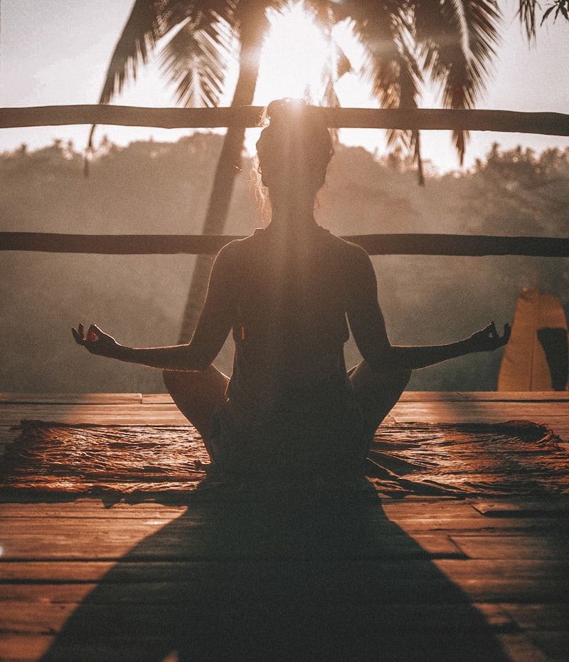 Woman meditating outdoors at sunset